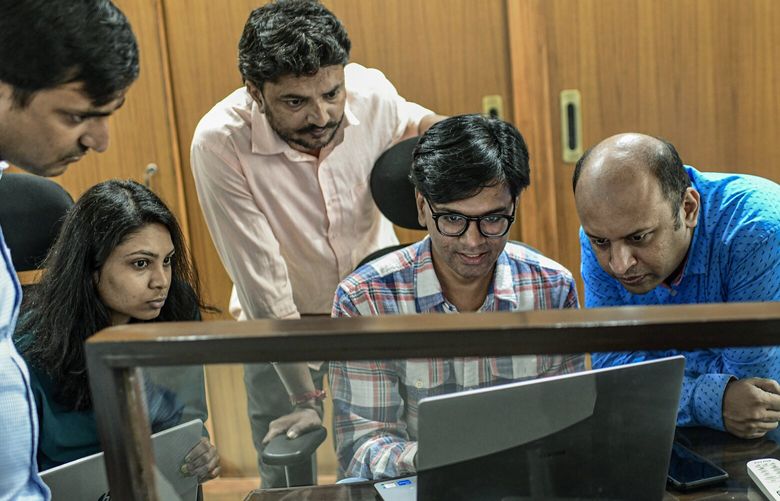 Cofounders Mohammed Zubair, center, and Pratik Sinha, right, work with staffers at the office of Alt News, in Ahmadabad, India, Aug. 22, 2022. AltNews has emerged as a leading debunker of misinformation in India, but highlighting hate speech against minorities has put it on a collision course with the government of Narenda Modi.  (Atul Loke/The New York Times)
