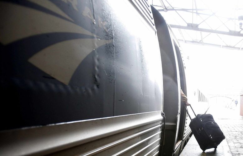 A traveler with, suitcase in tow, boards a west bound Amtrak train at the Amtrak train station in Harrisburg, Pa., Wednesday, Nov. 25, 2009,  the day before Thanksgiving. (AP Photo/Carolyn Kaster) PACK104