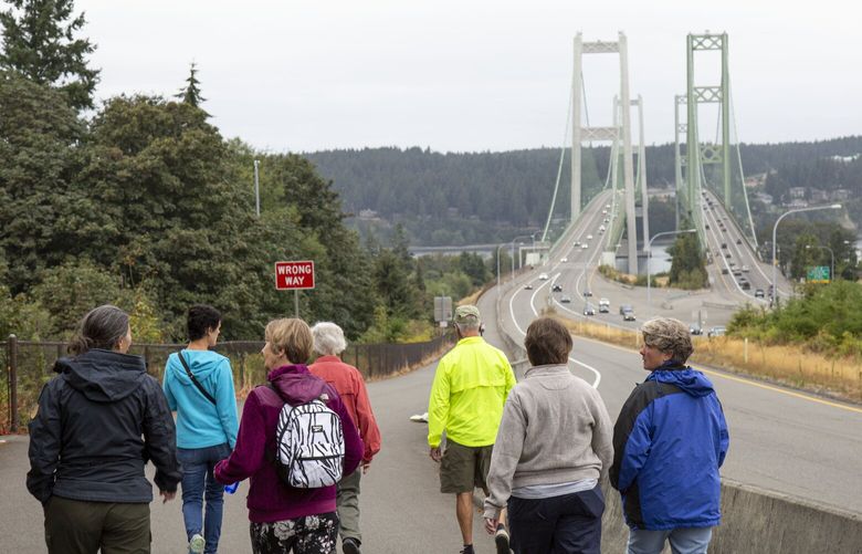 Members of a group called Tacoma Unlikely Walkers & Hikers make their way down to the Tacoma Narrows Bridge. Zach Powers