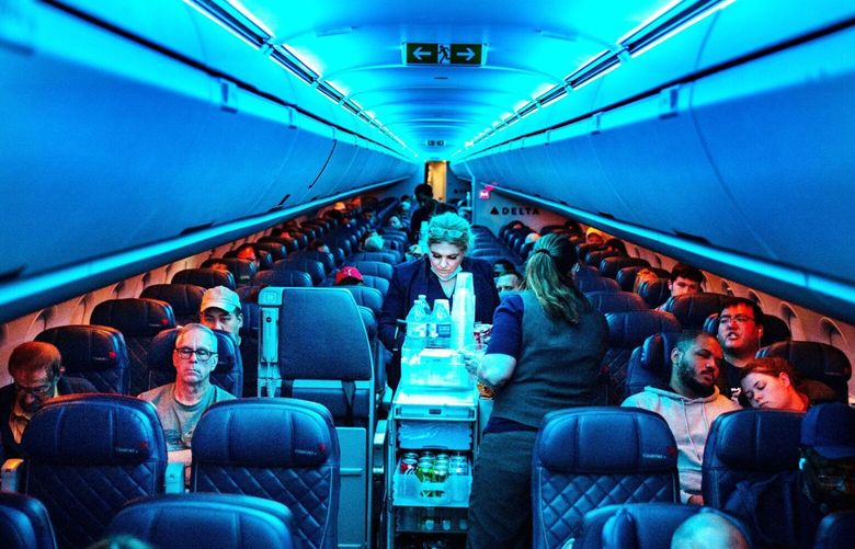 Flight attendants serve refreshments on a Delta Airlines flight from Hartsfield-Jackson International Airport on Monday, Aug. 1, 2022, in Atlanta, Georgia. (Kent Nishimura/Los Angeles Times/TNS)