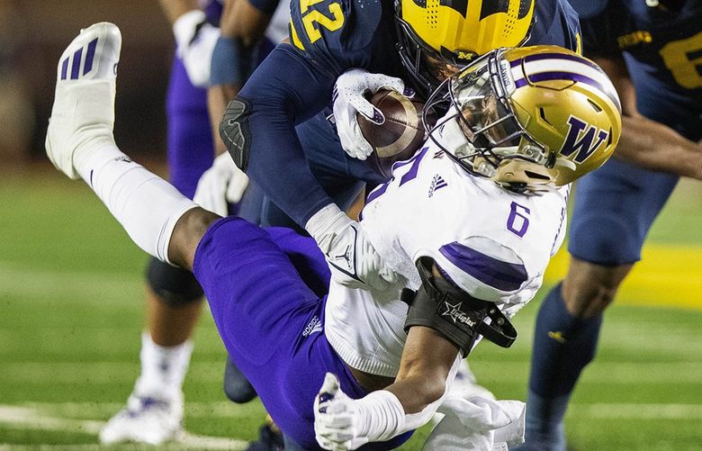Washington tailback Richard Newton is hit hard by Michigan linebacker Josh Ross in the 1st quarter, resulting in a 2-yard loss. The Washington Huskies played the Michigan Wolverines in NCAA Football Saturday, Sept. 11, 2021 at Michigan Stadium, in Ann Arbor, MI.