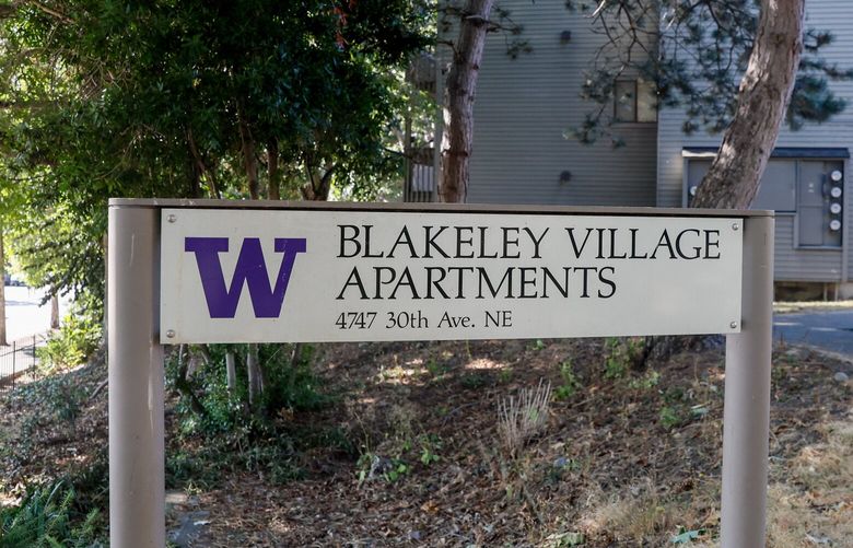 Cars drive on the access road to the University Village shopping center, left, as a sign welcomes visitors to Blakeley Village Apartments, Monday, Sept. 19, 2022, in Seattle. 221611