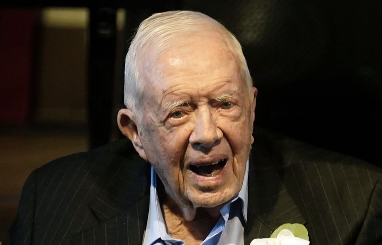 FILE – Former President Jimmy Carter reacts as his wife Rosalynn Carter speaks during a reception to celebrate their 75th wedding anniversary Saturday, July 10, 2021, in Plains, Ga.. (AP Photo/John Bazemore, Pool, File) WX103 WX103