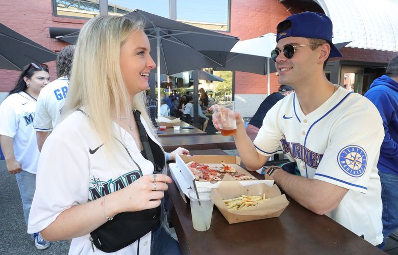 On the outside deck at Hatback bar and grille, just west of Mariners stadium, Mariners fans enjoy fresh beer and food, including fans Naomi MacDonald, left, and Bernie Agress. 221733