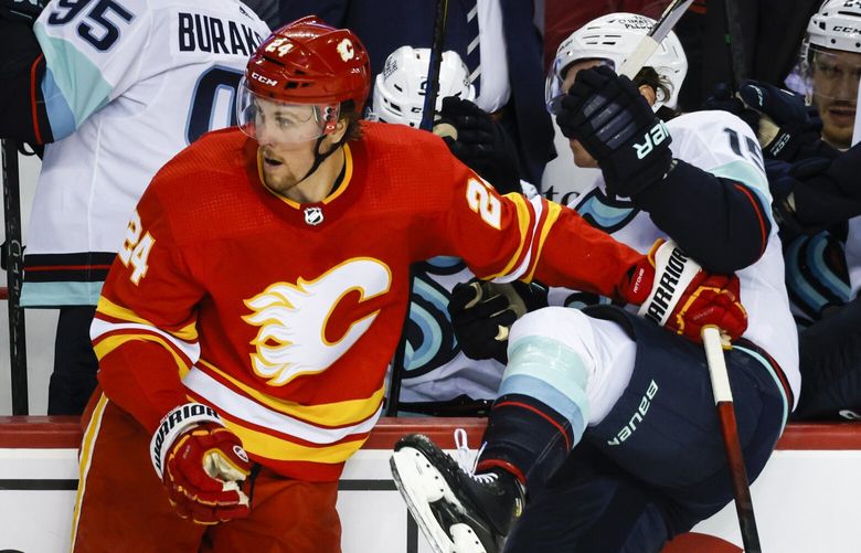 Seattle Kraken forward John Hayden, right, is checked by Calgary Flames forward Brett Ritchie during second-period NHL preseason hockey game action in Calgary, Alberta, Monday, Oct. 3, 2022. (Jeff McIntosh/The Canadian Press via AP)