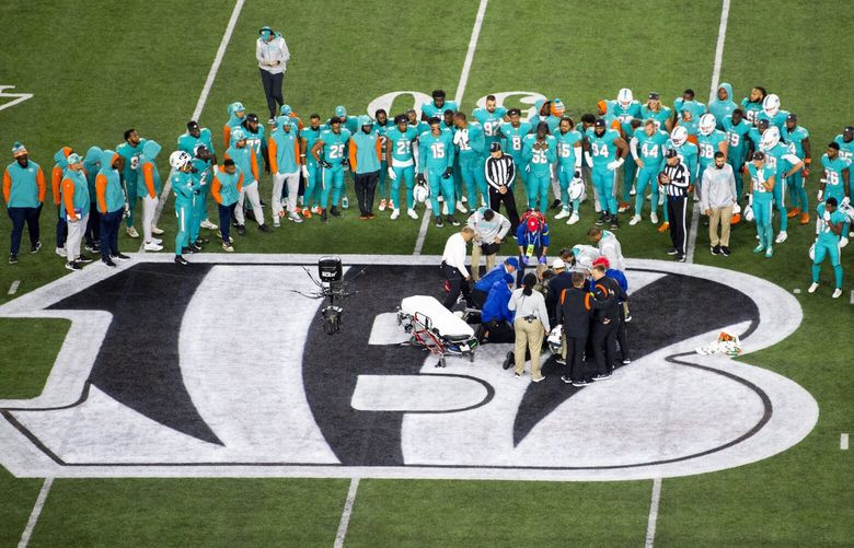 Teammates gather around Miami Dolphins quarterback Tua Tagovailoa (1) after an injury during the first half of an NFL football game against the Cincinnati Bengals, Thursday, Sept. 29, 2022, in Cincinnati. (AP Photo/Emilee Chinn) NY159