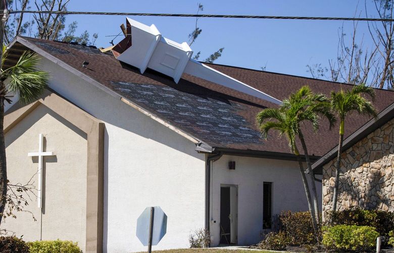 The steeple lays on its side atop Southwest Baptist Church in Fort Myers, Fla., on Sunday, Oct. 2, 2022. The church sustained heavy wind and flooding damage during Hurricane Ian as parishioners took refuge in the sanctuary. (AP Photo/Robert Bumsted) FLRB805