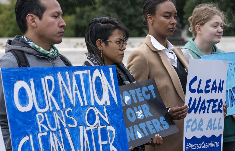 Jaime Sigaran, far left, with American Rivers, Maritza Mendoza, with GreenLatinos (cq), and Thea Louis, with Clean Water Action, join other supporters of the Clean Water Act as they demonstrate outside the Supreme Court, Monday, Oct. 3, 2022, in Washington, as the court begins arguments in Sackett v. Environmental Protection Agency (EPA). (AP Photo/Jacquelyn Martin) DCJM104 DCJM104