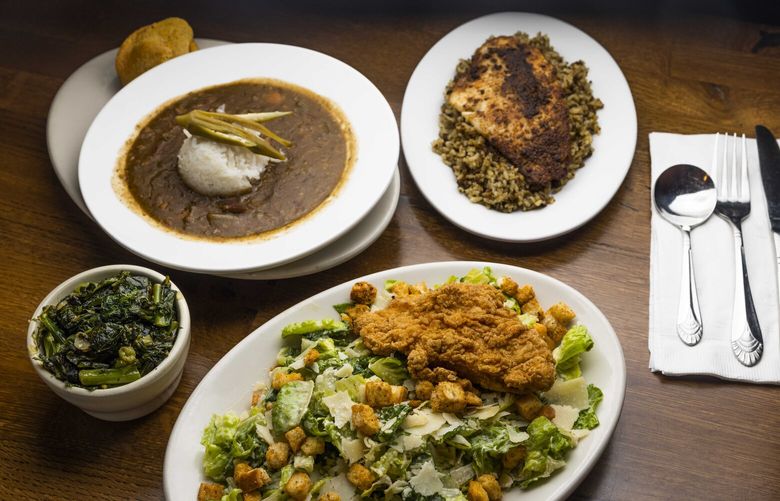 A blackened catfish with dirty rice, top right; gumbo, top left; fried chicken on a salad, bottom; and sautéed greens, left; are photographed at Jude’s Old Town on Oct. 4, 2022.