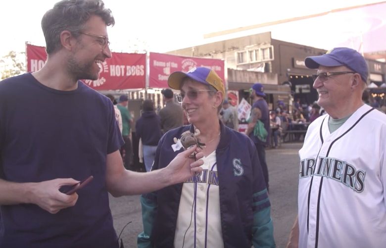 Seattle Times sports producer Chris Cole talks to Mariners fans about the playoffs outside of T-Mobile Park before their clinching victory over the A’s last weekend. (Ramon Dompor & Chris Cole / The Seattle Times)