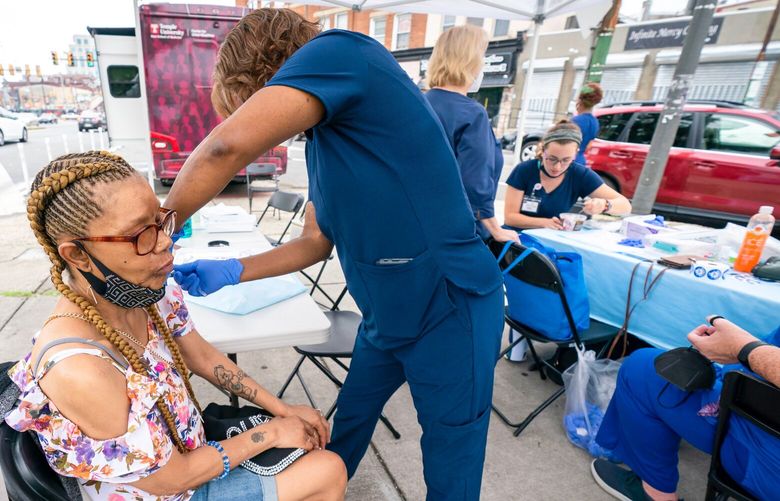 Patricia Washington receives a COVID booster shot from DeWanda Taylor in Philadelphia, August 1, 2022. 60153924P