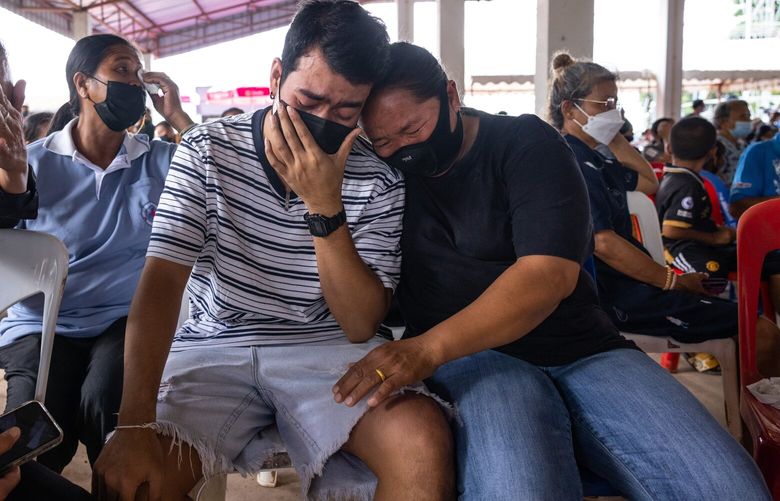 Relatives and friends of the victims of the mass shooting that left at least 36 dead, including 24 young children, at a child care center in Thailand’s Nong Bua Lamphu province, on Friday, Oct. 7,  2022. Authorities said the perpetrator, a recently-fired police officer who also killed his wife and daughter before killing himself, was set to go on trial this week for possession of methamphetamine. (Andre Malerba/The New York Times) XNYT5 XNYT5