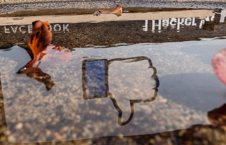 The Facebook logo reflected in a puddle at the company’s headquarters in Menlo Park, California, U.S., on Monday, Oct. 25, 2021.  (David Paul Morris/Bloomberg)