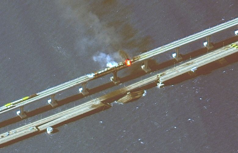 This infrared satellite image provided by Maxar Technologies shows damage to the Kerch Bridge, which connects the Crimean Peninsula with Russia crossing a strait between the Black Sea and the Sea of Azov, and rail cars on fire on Saturday, Oct. 8, 2022. (Maxar Technologies via AP) NY334 NY334