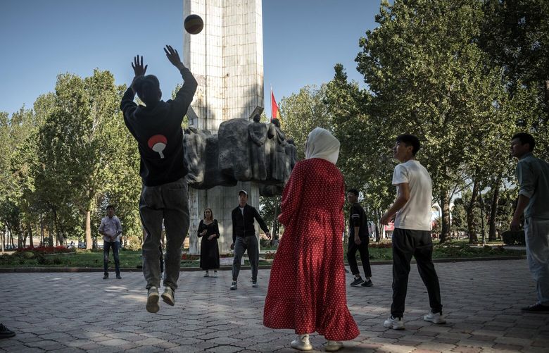 — EMBARGO: NO ELECTRONIC DISTRIBUTION, WEB POSTING OR STREET SALES BEFORE 12:01 A.M. ET ON SATURDAY, OCT. 8, 2022. NO EXCEPTIONS FOR ANY REASONS — A volleyball game near the Friendship of Nations Monument in Bishkek, Kyrgyzstan, Sept. 26, 2022. Russia’s domination of Central Asia and the Caucasus region is unraveling as the Kremlin focuses on the war in Ukraine while bloody border conflicts flare. (Sergey Ponomarev/The New York Times) XNYT204 XNYT204