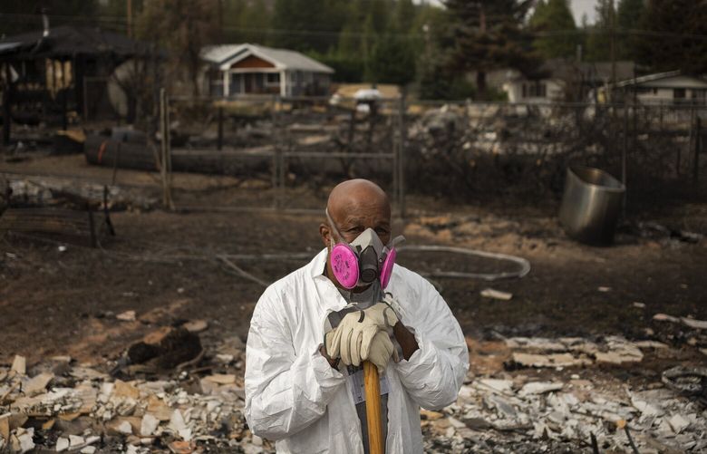 Chester Hopkins picking through the rubble of his Lincoln Heights home, which he owned for 40 years before it burned in the Mill fire, in Weed, Calif., Sept. 17, 2022. The Lincoln Heights community, a historically Black neighborhood, thrived for decades, despite segregation, economic hardship and a pandemic. (Brian L. Frank/The New York Times) XNYT109 XNYT109