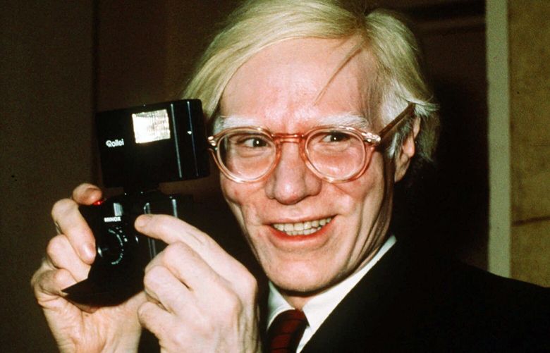FILE – In this 1976 file photo, pop artist Andy Warhol smiles in New York. Artist Any Warhol and the musician Prince were both center stage Wednesday in a case at the Supreme Court, a copyright case that had the justices discussing topics from Cheerios to the Mona Lisa. (AP Photo/Richard Drew, File) WX201 WX201