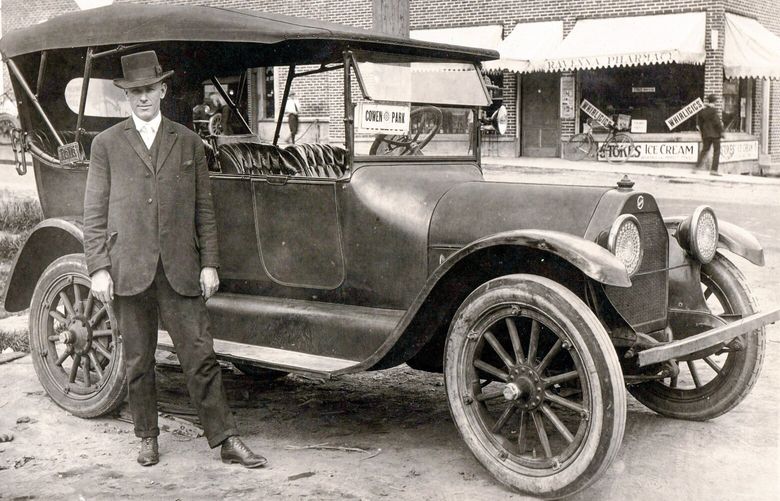 THEN: A taxi and likely its driver dominate this depiction of the northeast corner of Ravenna and 65th avenues northeast, likely in 1921. The four-cylinder touring car is a 1917 Studebaker Series 18 Model SF. The building behind it has, since 1920, housed a pharmacy, a cleaners, cooperatives and King County now.