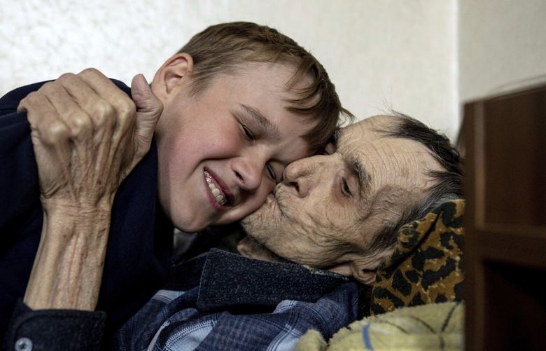 Mykola Svyryd, 70, hugs his son Bohdan, 13, in a shelter for injured and homeless people in Izium, Ukraine, Monday, Sept. 26, 2022. A young Ukrainian boy with disabilities, 13-year-old Bohdan, is now an orphan after his father, Mykola Svyryd, was taken by cancer in the devastated eastern city of Izium. (AP Photo/Evgeniy Maloletka) XFS101 XFS101