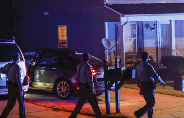 Raleigh Police officers walk door-to-door checking on residents in the Hedingham neighborhood and Neuse River Trail area in Raleigh, N.C., after five people were shot and killed Thursday, Oct. 13, 2022. (Travis Long/The News & Observer via AP) NCRAL907 NCRAL907
