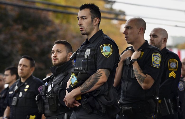 FILE – Police officers from towns across Connecticut stand at the scene where two police officers were killed, Thursday, Oct. 13, 2022, in Bristol, Conn. The deaths of two Connecticut police officers and the wounding of a third during an especially violent week for police across the U.S. fit into a grim pattern, law enforcement experts say. Even as the number of officers has dropped in the past two years, the number being targeted and killed has risen. (AP Photo/Jessica Hill, File) LA502 LA502