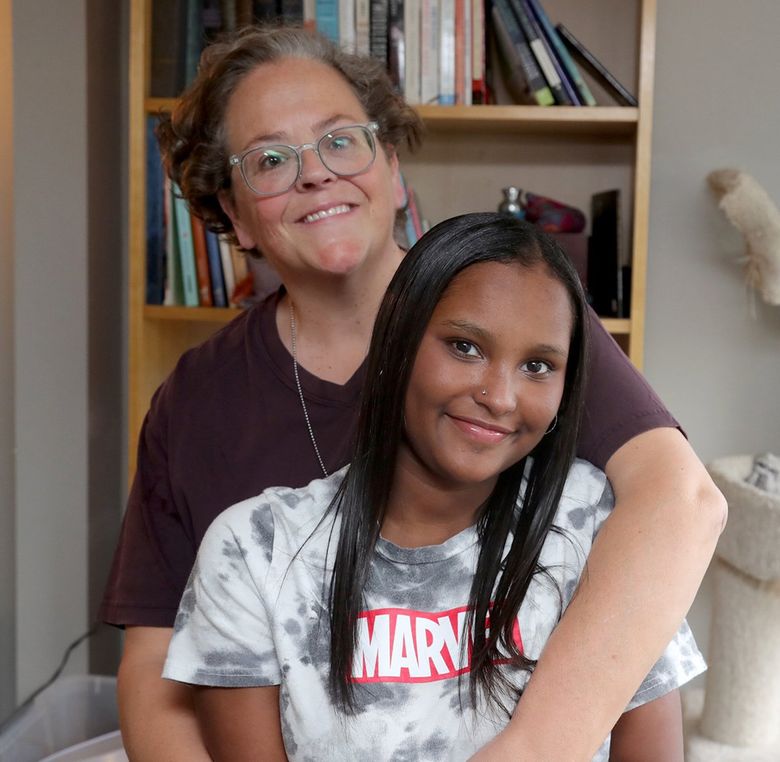 Andie Breuner hugs her daughter Feven Breuner, who has asthma. The wildfire smoke that smothered the Seattle area put an end to cheer practice and even going outside at all. (Greg Gilbert / The Seattle Times)