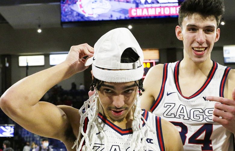 Gonzaga guard Andrew Nembhard, left, wears part of a basketball net as teammate Chet Holmgren gestures towards him after the team won the West Coast Conference regular season championship, after an NCAA college basketball game against Santa Clara, Saturday, Feb. 19, 2022, in Spokane, Wash. (AP Photo/Young Kwak) OTK