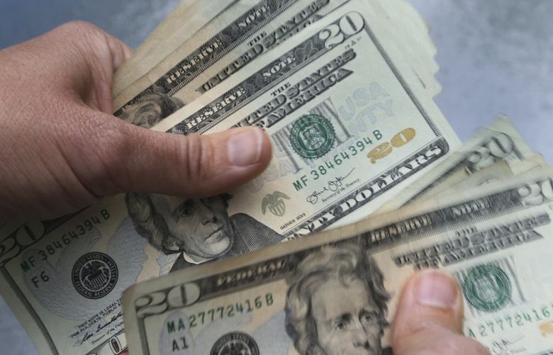 FILE – In this June 15, 2018 file photo, twenty dollar bills are counted in North Andover, Mass. (AP Photo/Elise Amendola, File) 