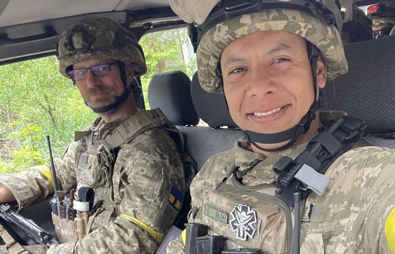 In this May 25 photo, Carl Larson, left, rides in a truck that delivered supplies from towns near Kharkiv to troops serving in the International Legion of Defense of Ukraine. He is with another legion member, Alfonso Caro, right.
