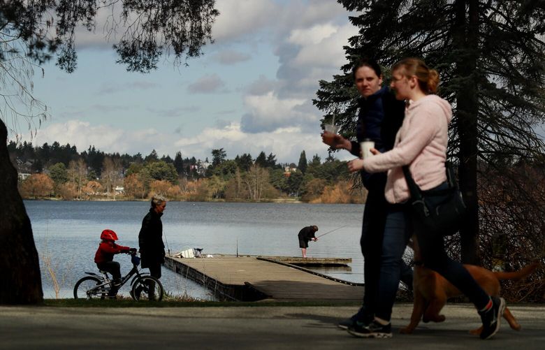 Pedestrians walk, bike and fish at Green Lake Park in Seattle Monday, March 23, 2020.  213436