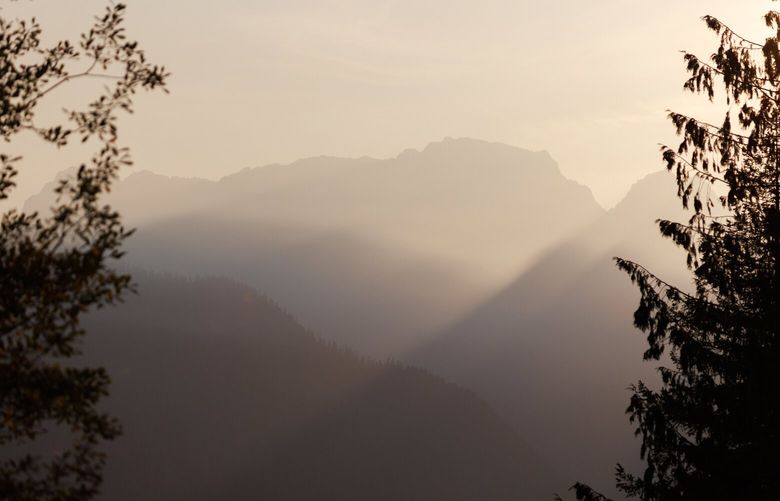 Smoke from the Bolt Creek Fire creates a hazy sunset in the Cascade Mountains near Highway 2 on Monday, Oct. 17, 2022. 221857