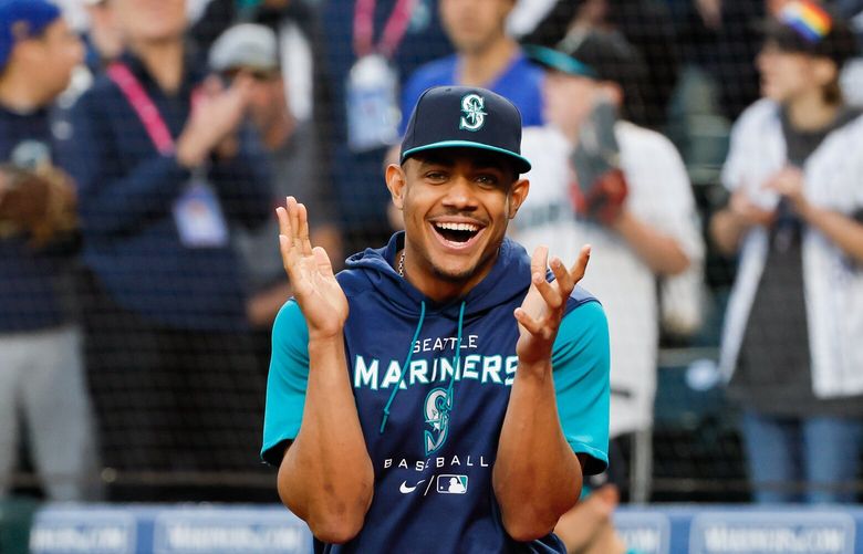 Seattle Mariners’ Julio Rodriguez claps as he walks up to accept the local chapter of the Baseball Writers’ Association of America award for Player of the Year before the start of a game against the Oakland Athletics. 221659