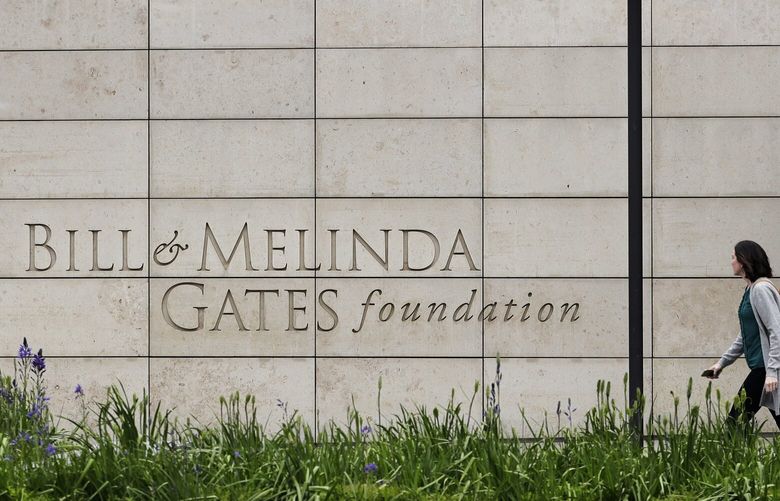 FILE – A person walks by the headquarters of the Bill and Melinda Gates Foundation on April 27, 2018, in Seattle. The Bill and Melinda Gates Foundation announced Sunday, Oct. 16, 2022, that it will commit $1.2 billion to the effort to end polio worldwide. (AP Photo/Ted S. Warren, File) NYAB702 NYAB702
