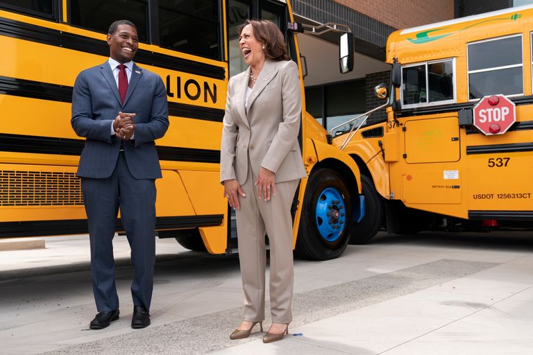 Vice President Kamala Harris laughs with Environmental Protection Agency Administrator Michael Regan during a tour of electric school buses