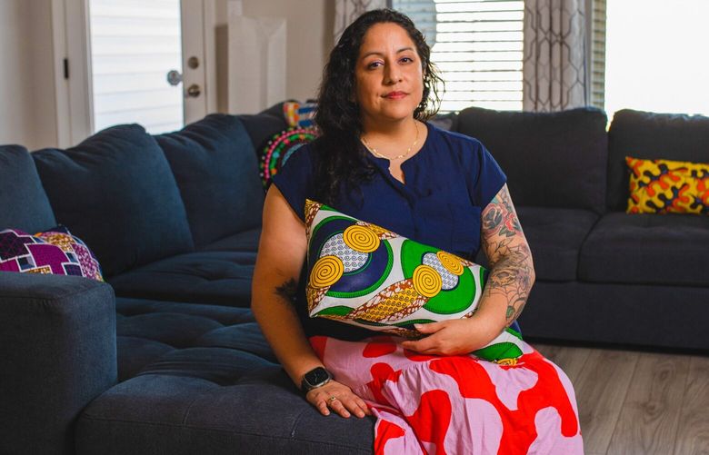 Daniela Capistrano, 40, founder and chief executive of DCAP Media, sits in the living room of the house they bought with their partner Tammara back in May 2022, 30 minutes outside of New Orleans, La., on Oct. 27 2022. MUST CREDIT: Photo for The Washington Post by Camille Lenain.