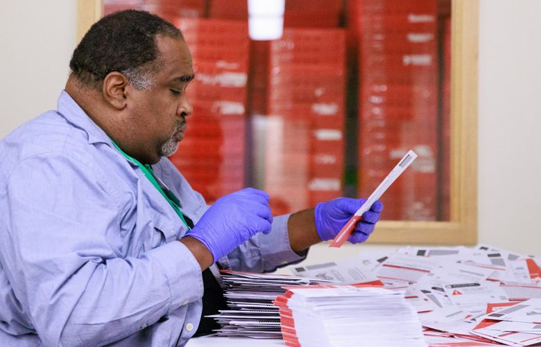 Joseph Emanuel prepares ballots for sorting at King County Elections headquarters in Renton, Wash. Tuesday, Aug. 2, 2022.  221153 (Erika Schultz / The Seattle Times)