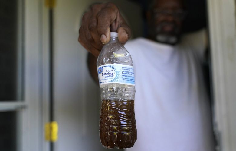 Toney Lewis shows a bottle of tap water he saved, before his neighborhood was recently switched to the current Ferriday, La. water system, in Ridgecrest, La., Tuesday, Sept. 13, 2022. In many places, people struggle to find water or else drink water that isn’t clean. (AP Photo/Gerald Herbert) CLI104 CLI104