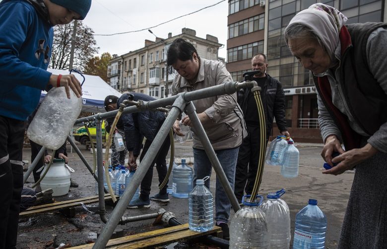 People fill plastic bottles with clean water at a humanitarian aid station in Mykolaiv, Ukraine, on Oct. 30, 2022. MUST CREDIT: Photo for The Washington Post by Heidi Levine