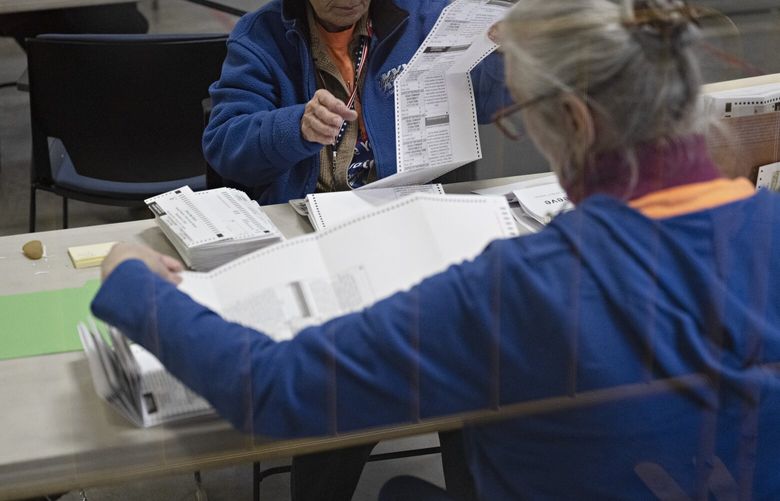 Workers separate ballots at the Clark County Election Department offices in North Las Vegas, on Nov. 4, 2022. Tedium and suspicion mix as skeptical observers monitor the largely monotonous work at a sprawling elections office near Las Vegas. (Bridget Bennett/The New York Times)