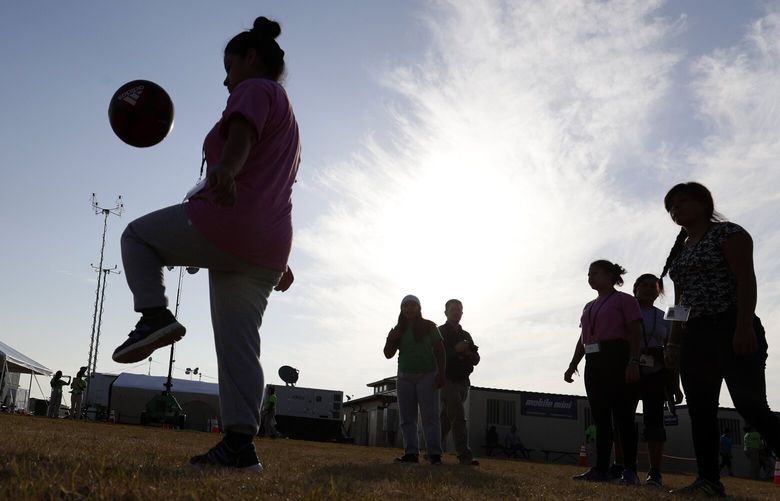 File – In this July 9, 2019, photo, immigrants play soccer at the U.S. government’s newest holding center for migrant children in Carrizo Springs, Texas. The U.S. government is taking new steps to ensure access to abortion services for pregnant migrant youths who are not accompanied by parents by assigning them to shelters in states that still allow abortion. (AP Photo/Eric Gay, File) LA405 LA405