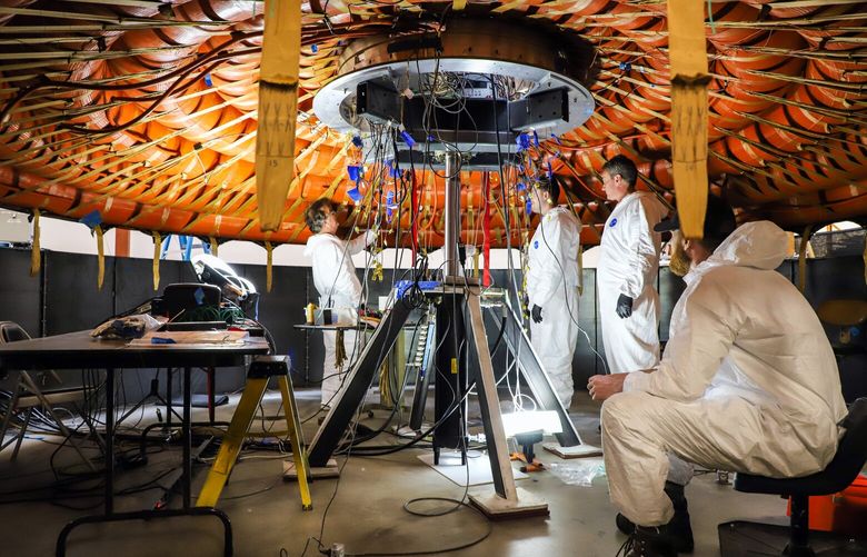 An undated photo provided by NASA shows engineers working on the LOFTID heat shield, which is designed to survive falling into the atmosphere at more than 18,000 miles per hour and temperatures over 3,000 degrees Fahrenheit. The LOFTID mission on Thursday, Nov. 10, 2022, tested a novel approach to guiding spacecraft through the extreme heat of returning from orbit, which could be used to put people on Mars. (NASA via The New York Times) 