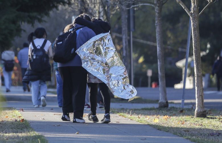 A child and parent make their way home Tuesday afternoon at Ingraham High School in Seattle, Washington on November 8, 2022.