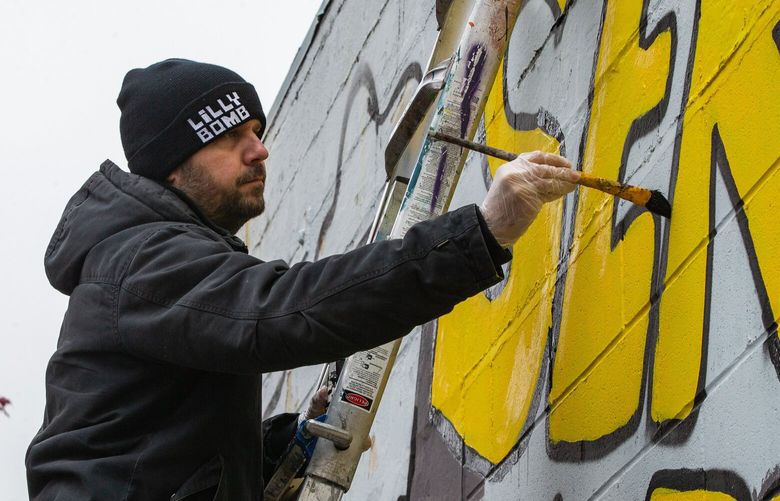 Artist and veteran Chris Kent of Lilly Bomb Studios paints his “Service with Pride” mural during a community paint event at Ballard Eagleson VFW Post 3063 on Veterans Day, Friday, Nov. 11, 2022.