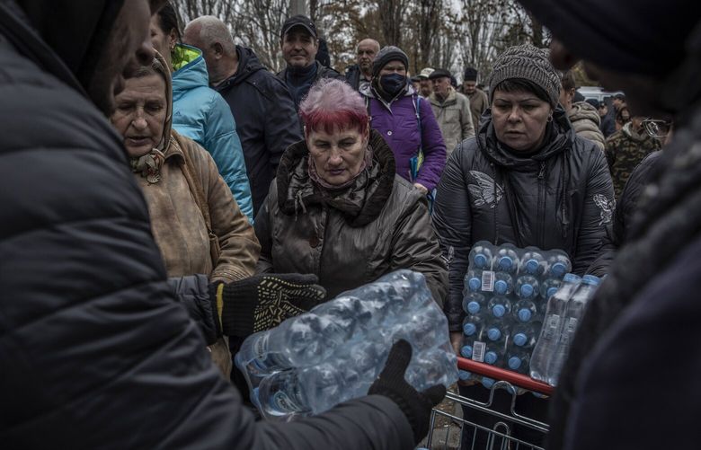 **EMBARGO: No electronic distribution, Web posting or street sales before 3:01 a.m. ET Saturday, Nov. 12, 2022. No exceptions for any reasons. EMBARGO set by source.** FILE — People line up to receive bottled water in the southern Ukrainian city of Mykolaiv, which has been without potable tap water for months, Nov. 11, 2022. Russia’s military operations in Ukraine will remain stalled well into next year, with the coming winter expected to bring a slowdown in military advances on both sides, senior Biden administration officials say. (Finbarr O’Reilly/The New York Times) XNYT140 XNYT140