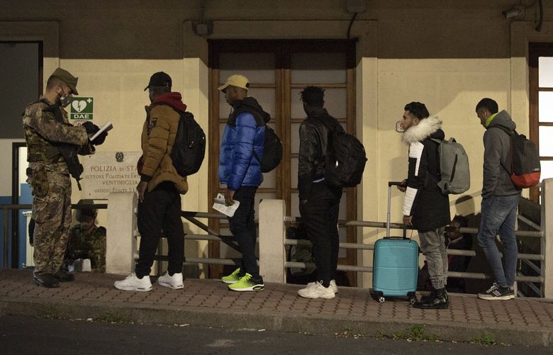 Migrants line up to be checked by Italian authorities at the Italian French border of Ventimiglia, Italy, Saturday, Nov. 12, 2022. (Marco Alpozzi/LaPresse via AP) VEN802 VEN802