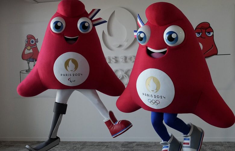 Mascots of the 2024 Paris Olympic Games, right, and Paralympics Games, a Phrygian cap, jump during a preview in Saint Denis, outside Paris, Thursday, Nov. 10, 2022. The soft bright red cap, also known as a liberty cap, is an updated version of a conical hat worn in antiquity in places such as Persia, the Balkans, Thrace, Dacia and Phrygia, where the name originates, in modern day Turkey. It later became a symbol of the pursuit of liberty in the French Revolution and is still worn by the figure of Marianne, the national personification of France since that time. (AP Photo/Christophe Ena) XPAR103 XPAR103