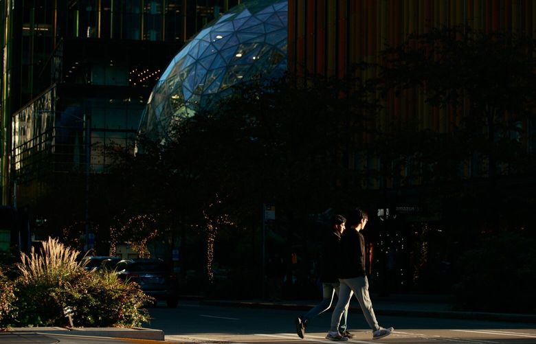 Pedestrians walk by Amazon’s offices at the corner of Seventh Avenue and Blanchard Street in Seattle on Tuesday, Nov. 15, 2022. 222198