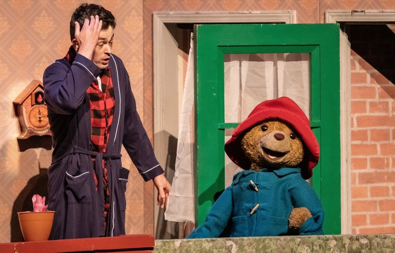 Kenon Veno (as Mr.Curry) and Paddington Bear in “Paddington Saves Christmas,” at Seattle Children’s Theatre through Dec. 31.