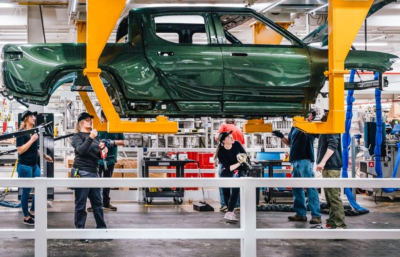 Workers assembly components of a Rivian R1T electric vehicle (EV) pickup truck at the company’s manufacturing facility in Normal, Illinois, US., on Monday, April 11, 2022. Rivian Automotive Inc. produced 2,553 vehicles in the first quarter as the maker of plug-in trucks contended with a snarled supply chain and pandemic challenges. Photographer: Jamie Kelter Davis/Bloomberg 775799011