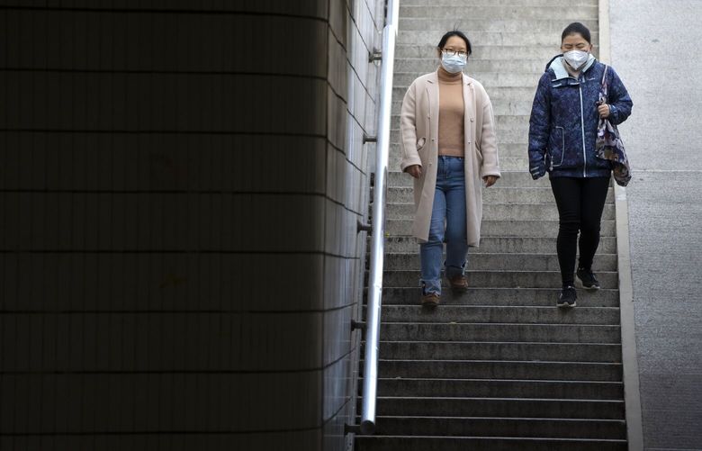 Commuters wearing face masks walk through a pedestrian underpass in Beijing, Wednesday, Nov. 16, 2022. Chinese authorities locked down a major university in Beijing on Wednesday after finding one COVID-19 case as they stick to a “zero-COVID” approach despite growing public discontent. (AP Photo/Mark Schiefelbein) XMAS104 XMAS104
